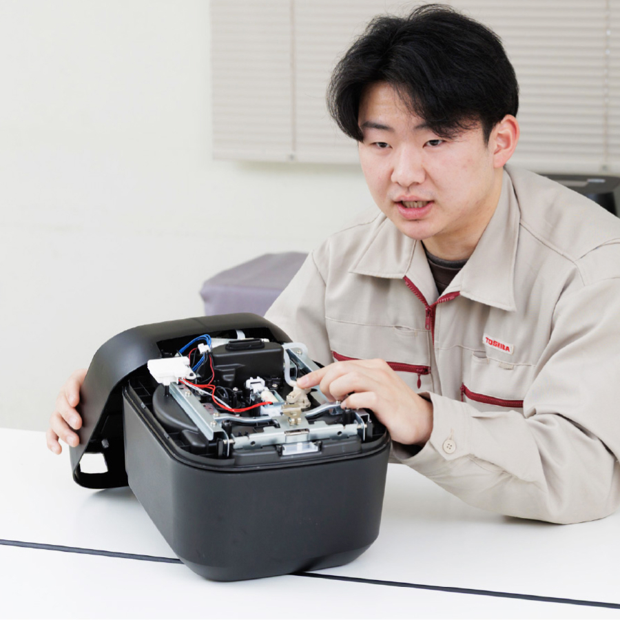 水が違えば、ごはんの味も違う。その事実から開発ははじまりました。炊飯器の内部を確認する東芝の開発者。